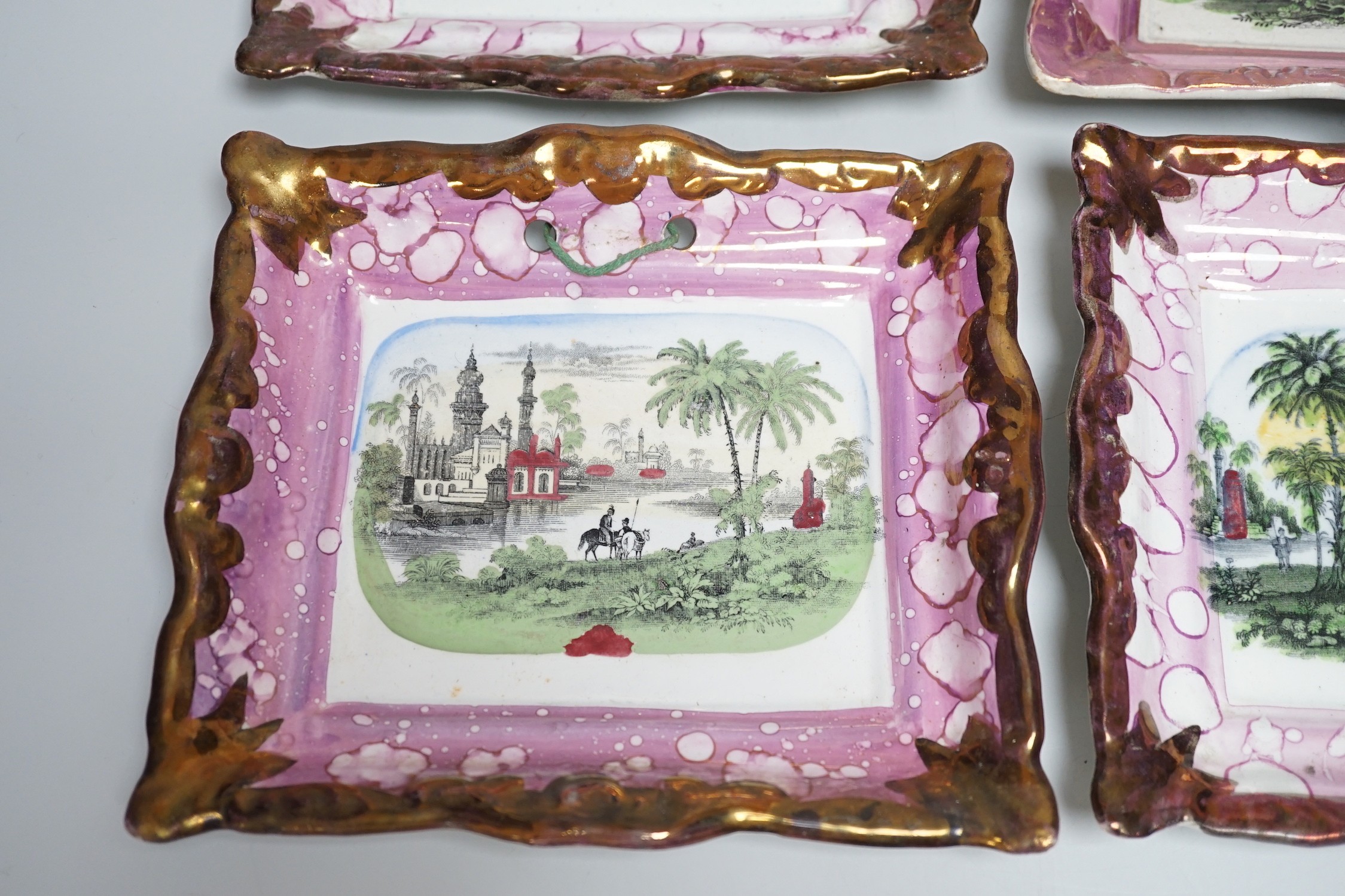 A set of four Dixon and Co. Sunderland pink lustre rectangular plaques, with copper lustre borders printed and hand coloured, impressed marks, 22cm wide